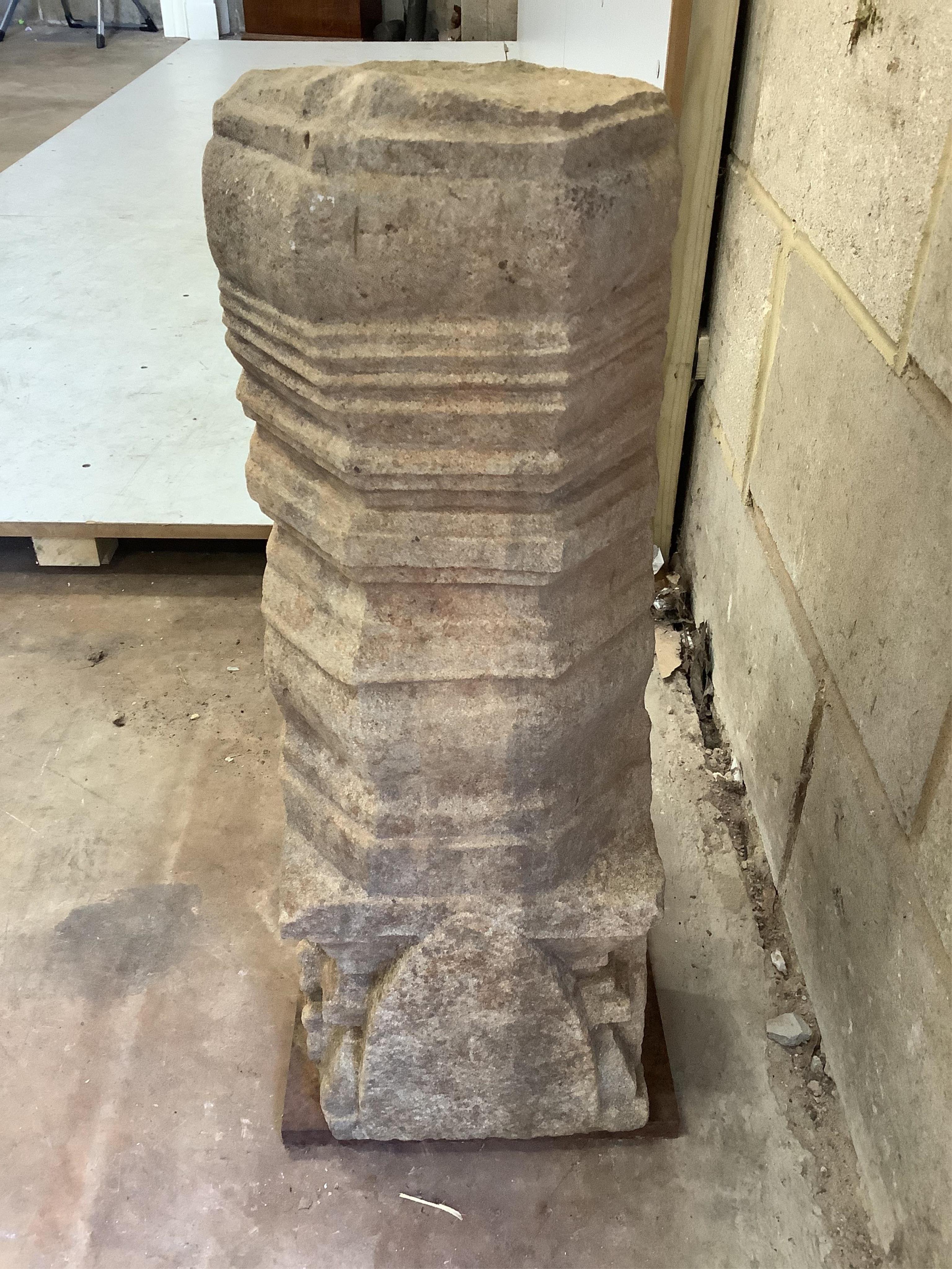 An Indian sandstone pillar with a wrought iron base, height 62cm. Condition - fair
